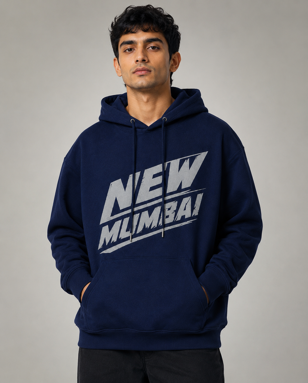 A man wearing a navy blue pullover hoodie with a bold white graphic reading 'NEW MLIMBA!' across the chest, posed against a neutral gray studio background.