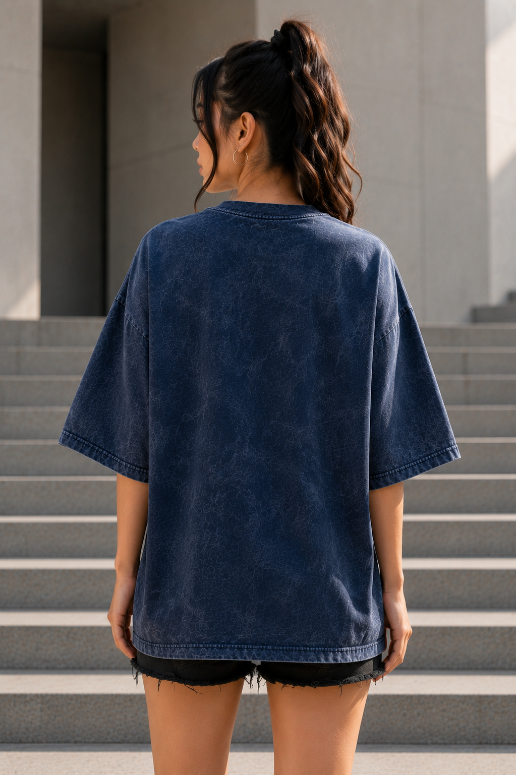 Back view of women's navy acid-wash oversized T-shirt with plain blank back